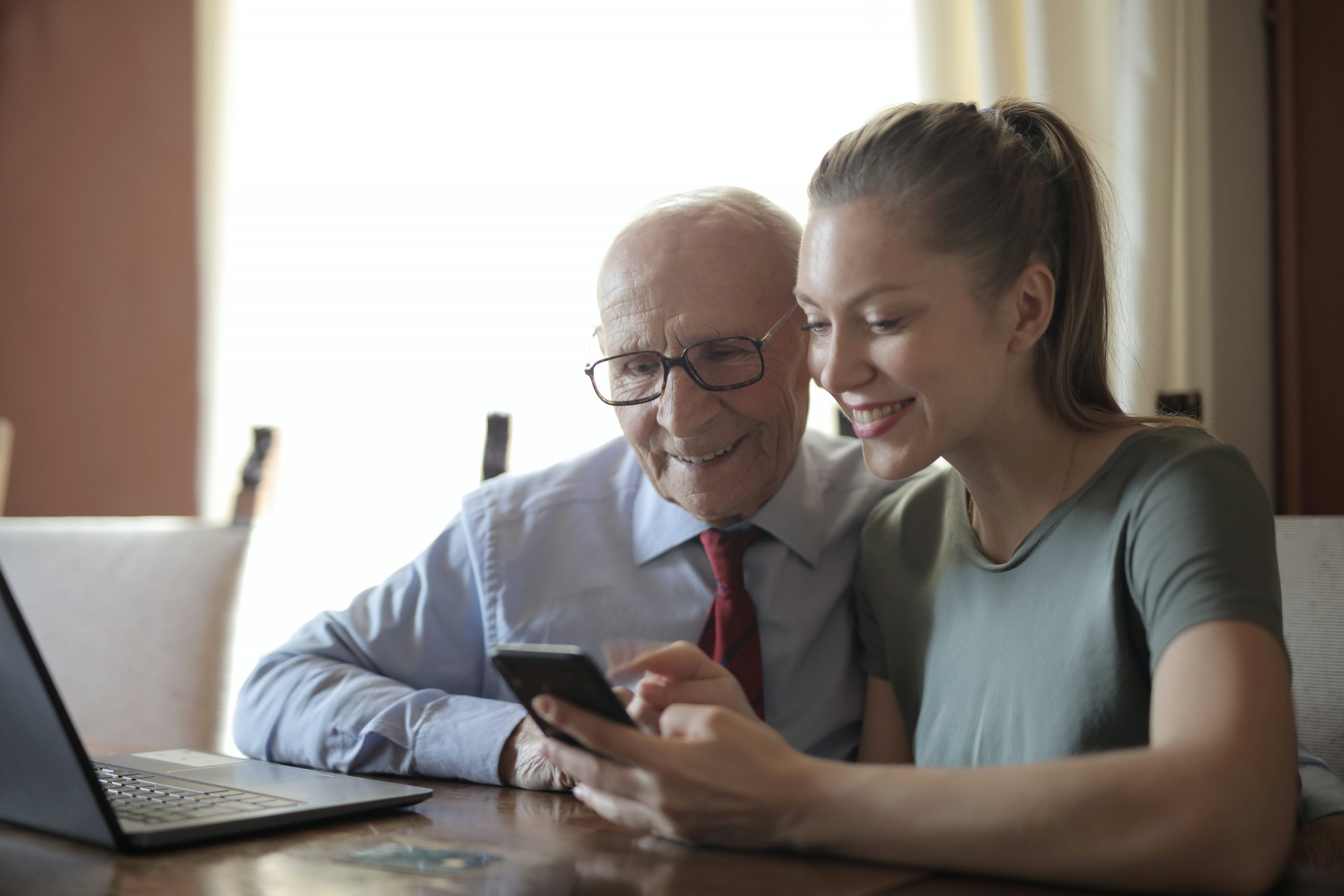 Mädchen erklärt Senior ein Handy